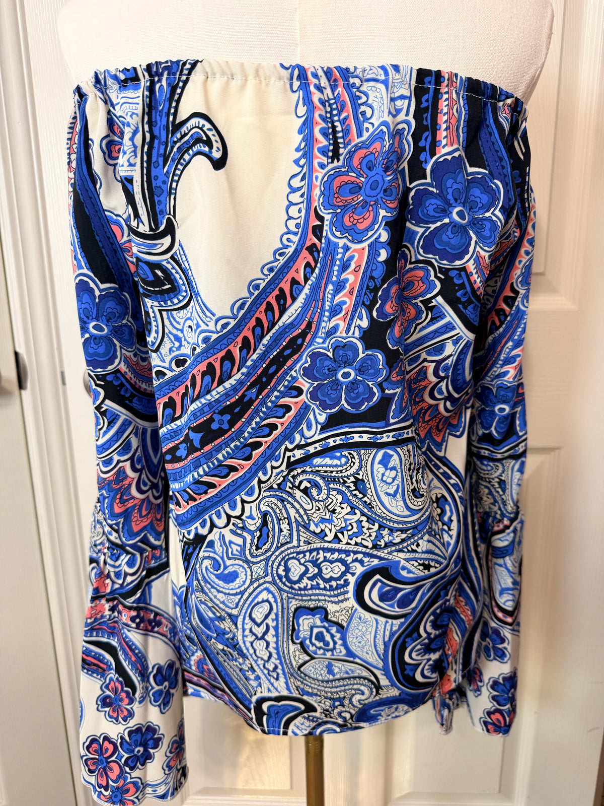 On or off-the-shoulder top smocked elastic neckline and flared bell sleeves.