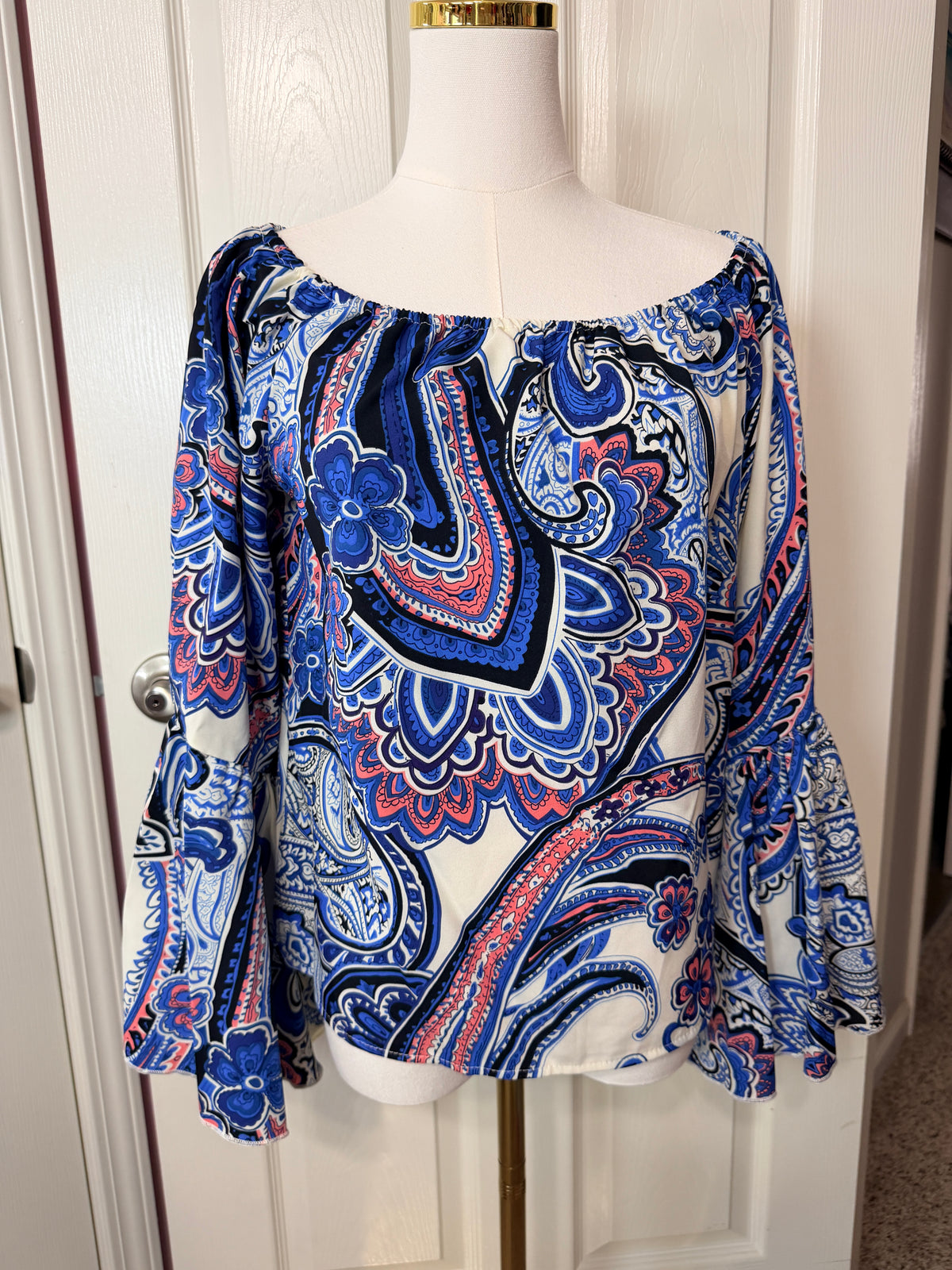 On or off-the-shoulder top smocked elastic neckline and flared bell sleeves.