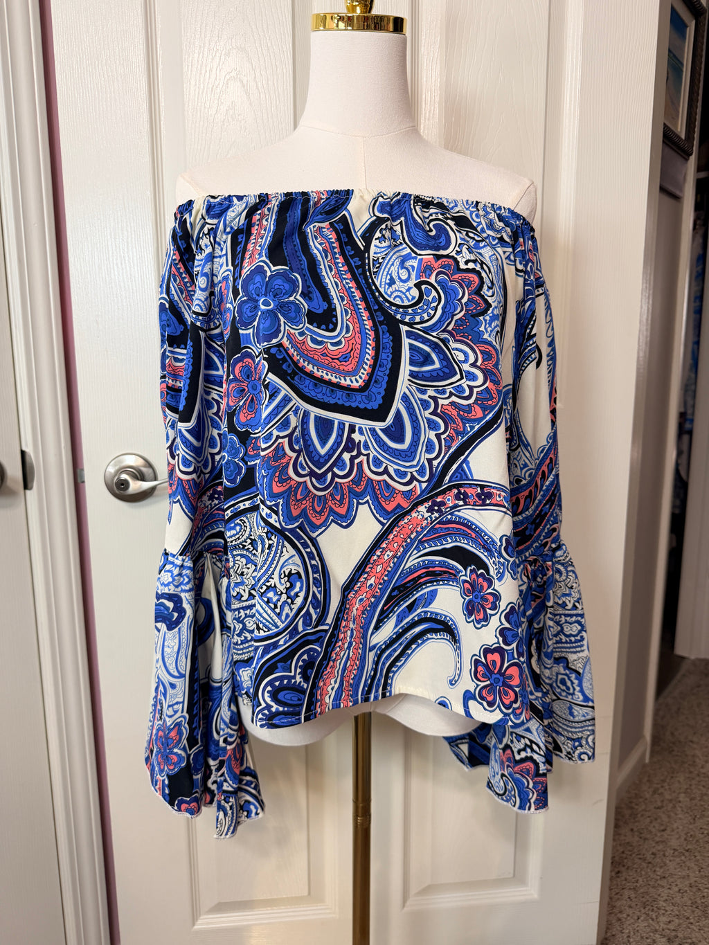 On or off-the-shoulder top smocked elastic neckline and flared bell sleeves.