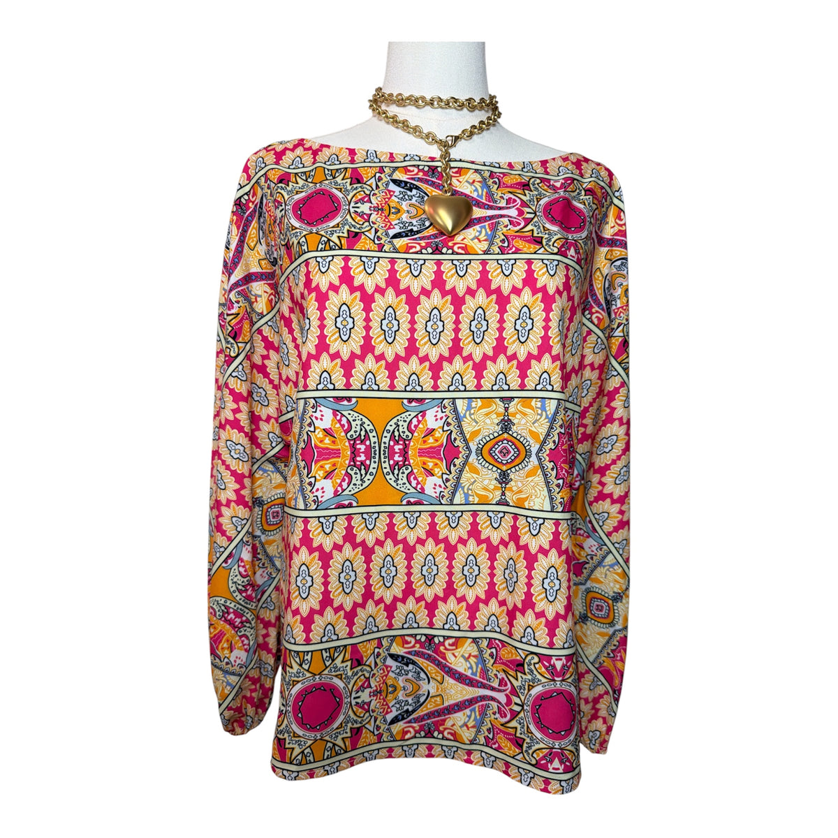 long-sleeve blouse features a bold geometric and paisley print with a boat neckline.